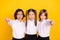 Photo of three upset frustrated schoolchildren show thumb down wear white shirt isolated yellow color background