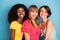 Photo of three young attractive cheerful woman best friends happy positive smile afro isolated over blue color