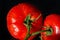 Photo tomatoes with drops of water on a black background