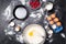 Photo on top of eggs, milk, flour, berries on black table.