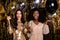 Photo of tow amazed festive ladies hold glasses champagne bottle party  on shine glitter bright background