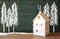 Photo of toy house in front of chalkboard with winter concept drawings