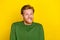 Photo of tricky funny man wear green pullover biting lip empty space isolated yellow color background