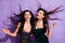 Photo of two crazy gorgeous ladies dance wind blow hair shiny smile wear dresses isolated purple color background
