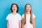 Photo of two curious excited schoolkids look empty space wear white t-shirt isolated blue color background