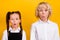 Photo of two excited shocked schoolkids omg reaction wear school uniform isolated yellow color background
