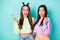 Photo of two funny cheerful ladies hold lollipop chupa chups hands crazy childish mood wear cropped pullovers naked