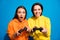 Photo of two funny ladies holding in hands joystick playing exciting video game rejoicing wear casual bright yellow