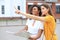 Photo of two girls enjoying sightseeing outdoor. Beautiful female tourists exploring city with map