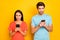 Photo of two guy lady people couple hold telephones hands reading negative post comments open mouth wear casual blue