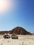 Photo of two jeeps on background of mountain, sand blue sky
