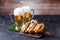 Photo of two mugs with beer, hamburgers on cutting board, soccer ball