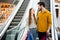 Photo of two people cheer attractive lady handsome guy couple enjoy free time buy carry many bags moving down escalator