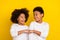 Photo of two positive siblings look each other hand give fist bump isolated on yellow color background