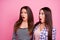 Photo of two shocked impressed pretty girls open mouth look empty space isolated on pink color background