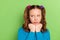Photo of unhappy sad upset small girl look empty space hold hands face bad mood isolated on green color background