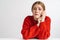 Photo of unhappy woman looking at camera while sitting at table