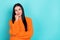 Photo of unsure suspicious woman wear orange sweater arm cheek looking empty space isolated turquoise color background