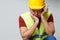 Photo of upset builder man in yellow helmet with walkie-talkie.
