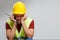 Photo of upset builder in yellow helmet with walkie-talkie.