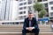 Photo Upset Young Businessman Sitting On Bench. Disappointed businessman sitting on a wooden bench with bottle in his hand  in