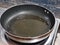 Photo of used frying pan with oil on the stove.