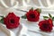 Photo Valentines charm red roses on white satin cloth background