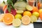 Photo of variety of citrus fruits, cut in half, lie on table against background of green leaves of mint. Detox concept . Close up