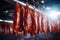 Photo of a variety of meats hanging on a line in a market or butcher shop. Industrial smoking of sausages and meat products. Farm