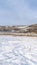 Photo Vertical frame Field with snow in winter with homes on snowy hill against sky backgdrop