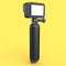 Photo and video lightweight black action camera with monopod on yellow