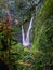 Photo of a waterfall in the middle of the forest known as twin waterfalls or curug kembar at the lembah purba, Situgunung sukabumi