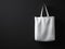 Photo white color cotton textile material bag hanging right side. Empty concrete black painted wall background. Highly