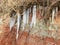 Photo with white ice icicles on the red clay walls