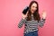 Photo of winking beautiful happy young woman wearing striped sweater isolated over background with copy space showing ok