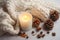 photo of winter composition lighted candles white knitted sweater pine cones and anise on a pastel backgroun