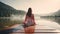 Photo of a woman sitting on a dock by a serene lake