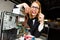 Photo of women with glasses gnawing wires at table next to broken processor