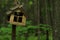 Photo of wooden birdhouse in cold summer forest