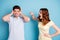 Photo of yelling wife scolding negative expression husband hiding ears wear casual t-shirts isolated blue background