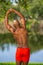 Photo of a young African American fitness model stretching in the park. Man posing shirtless showing muscles