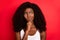 Photo of young african girl unhappy upset hand touch chin think look empty space isolated over red color background