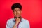 Photo of young african guy hand touch chin think curious idea look empty space isolated over red color background