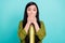 Photo of young asian girl cover lips hands oops fail tell speak secret worried isolated over teal color background