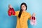 Photo of young asian girl unhappy upset decide what to wear solution decision high-heels sneakers isolated over blue