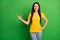 Photo of young attractive girl happy smile point finger empty space ad promo choice choose isolated over green color