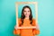 Photo of young attractive girl hold wooden photo frame look through it isolated over teal color background