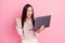 Photo of young attractive smiling businesswoman celebrating addicted online player betting laptop isolated on pink color