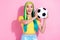 Photo of young beautiful amazed female catch football ball sportive player have fun isolated on pink color background