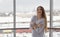 Photo of young beautiful happy smiling woman with long hair near the window.